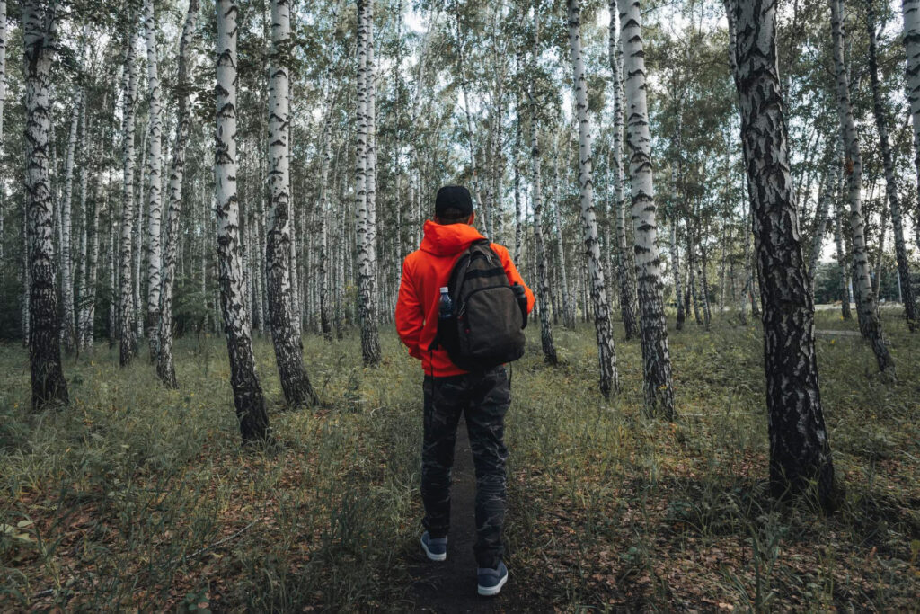 Navigating Like a Pro: How to Use a Compass and Map Man hiking in woods